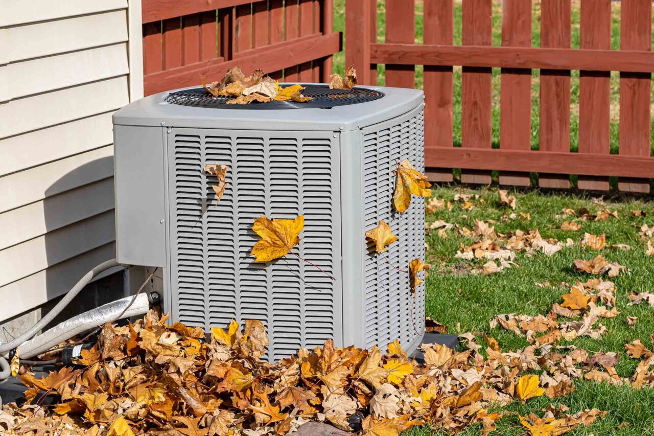 Home air conditioning/HVAC behind the house during the autumn