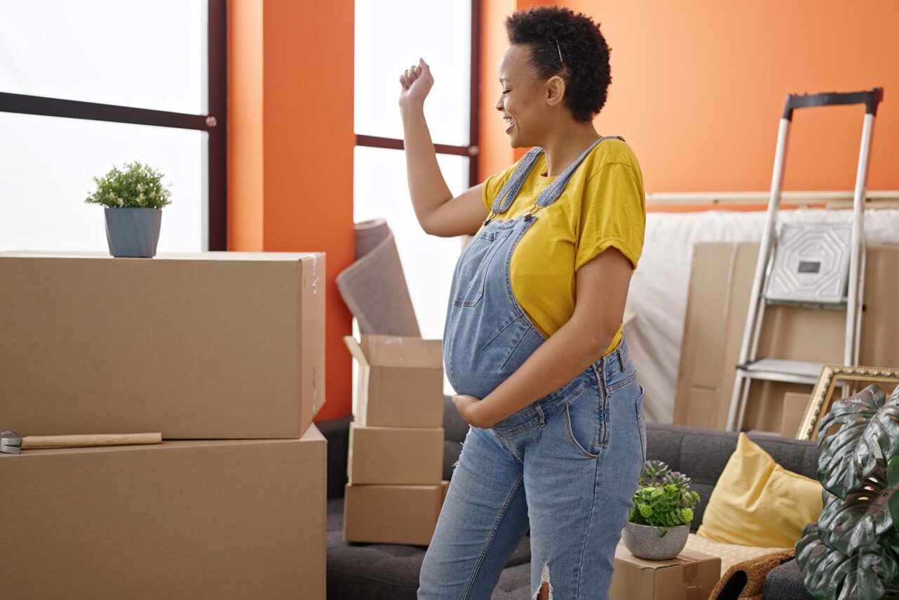 Young pregnant woman smiling confident dancing at new home