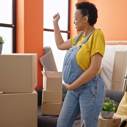 Young pregnant woman smiling confident dancing at new home