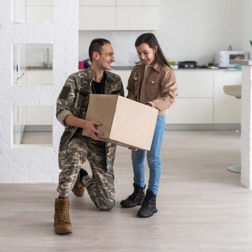 Happy military serviceman holding cardboard box with girl.