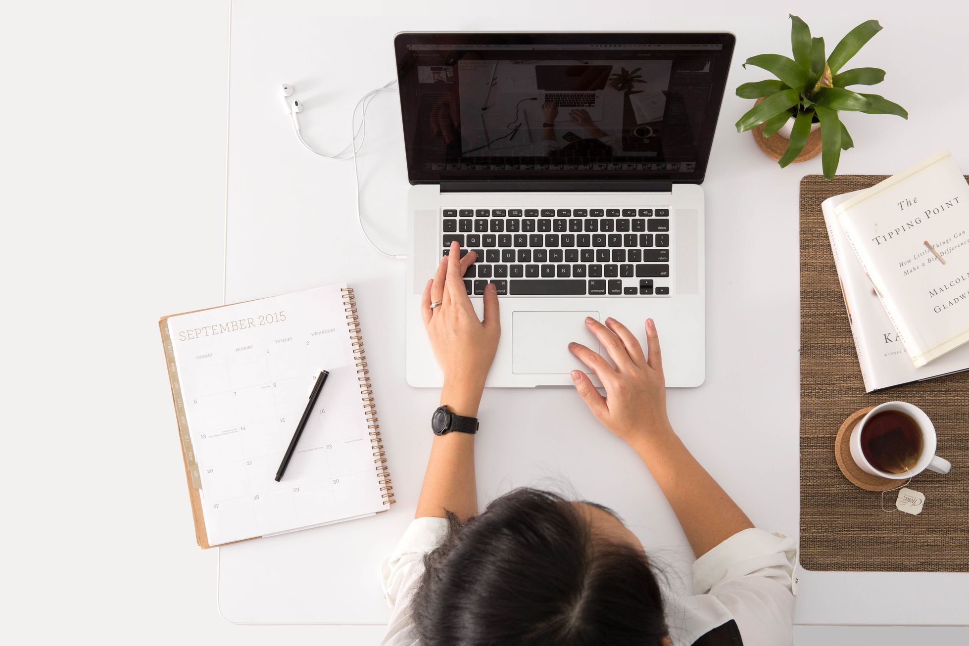 woman is creating a list and using laptop