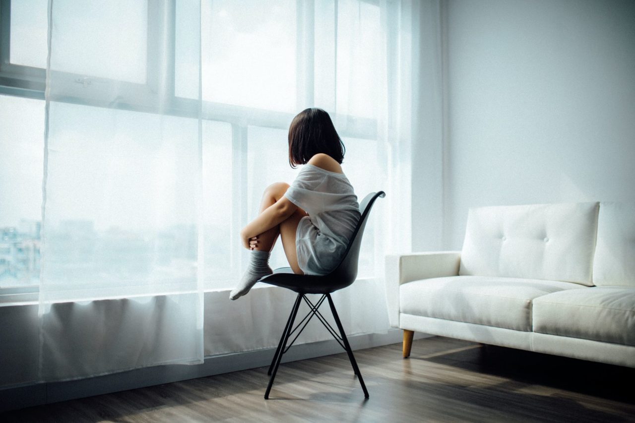 Girl sitting in a room after moving long-distance