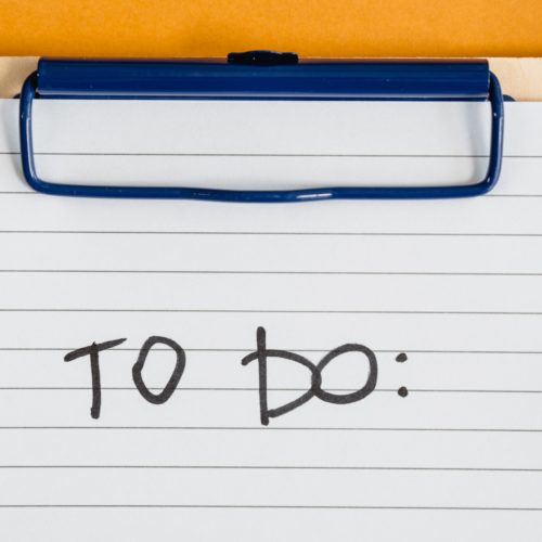 a paper on a clipboard with the words 'to do' written on it for planning long-distance moving