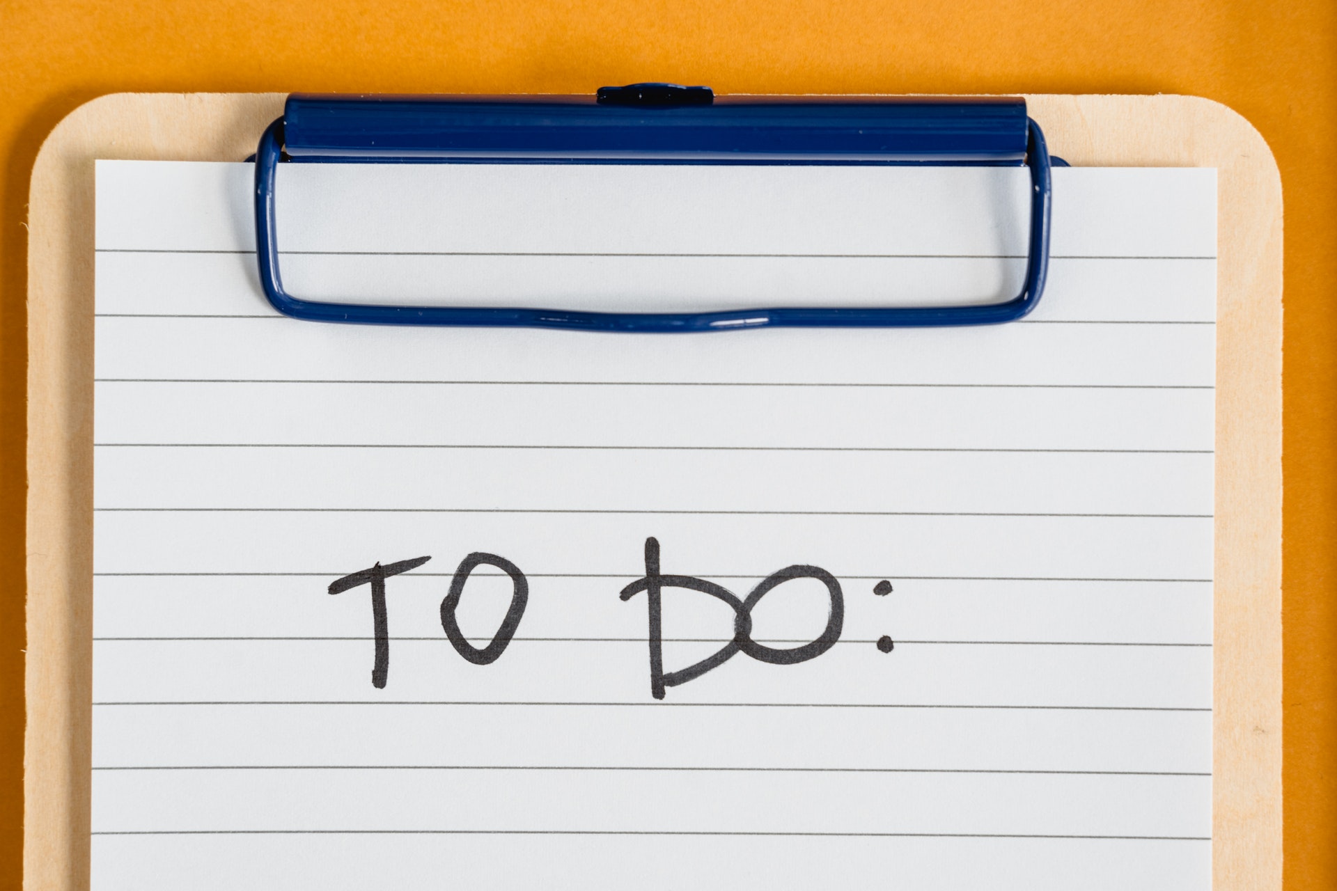 a paper on a clipboard with the words 'to do' written on it for planning long-distance moving