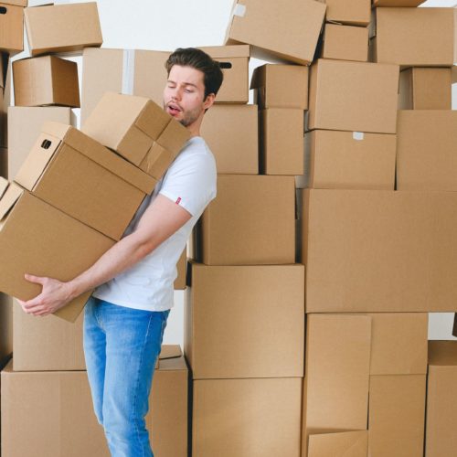 A man carrying boxes before the long-distance movers come